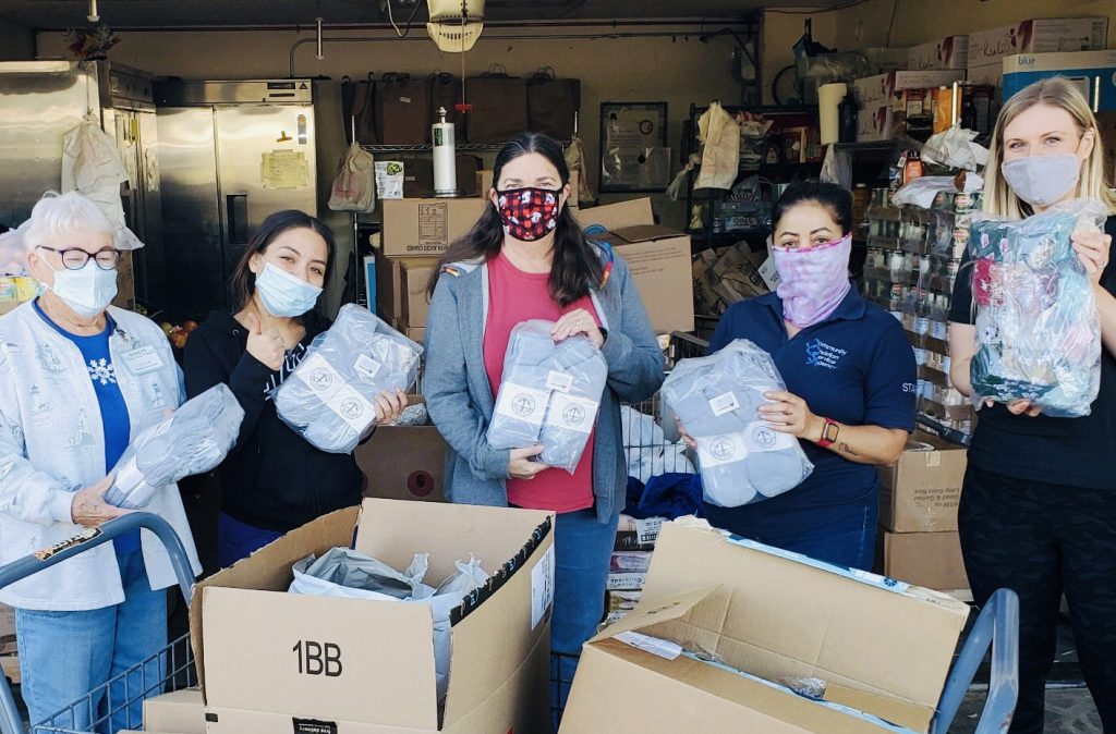Swenson Children's Foundation staff holding socks to be donated